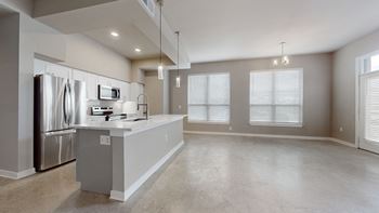 An empty kitchen with stainless steel appliances and a counter top